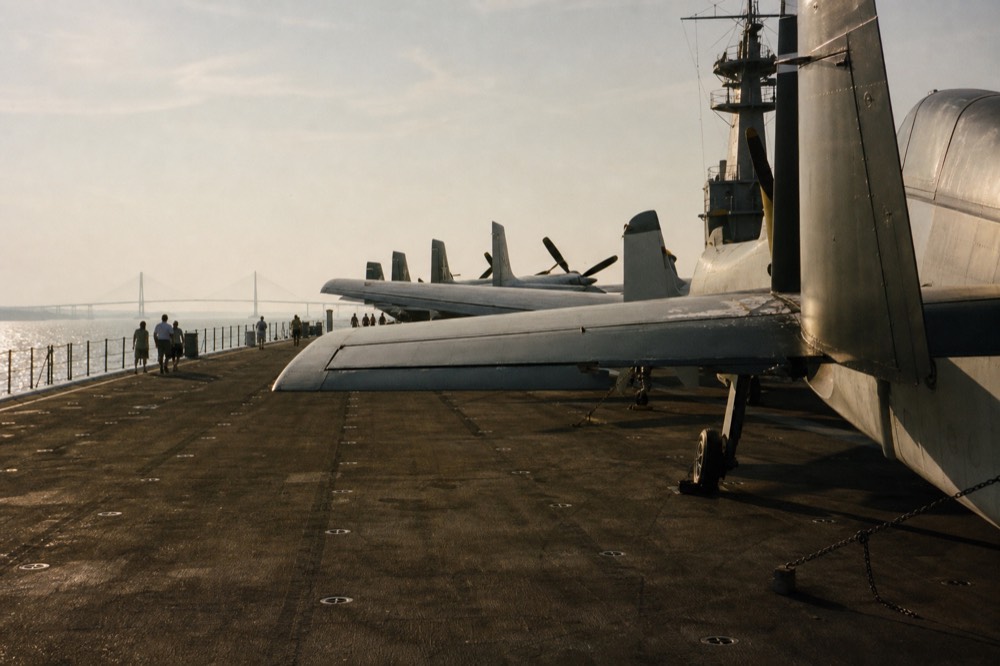 Restored vintage aircraft lined up on the carrier flight deck, no text, no logos, no people