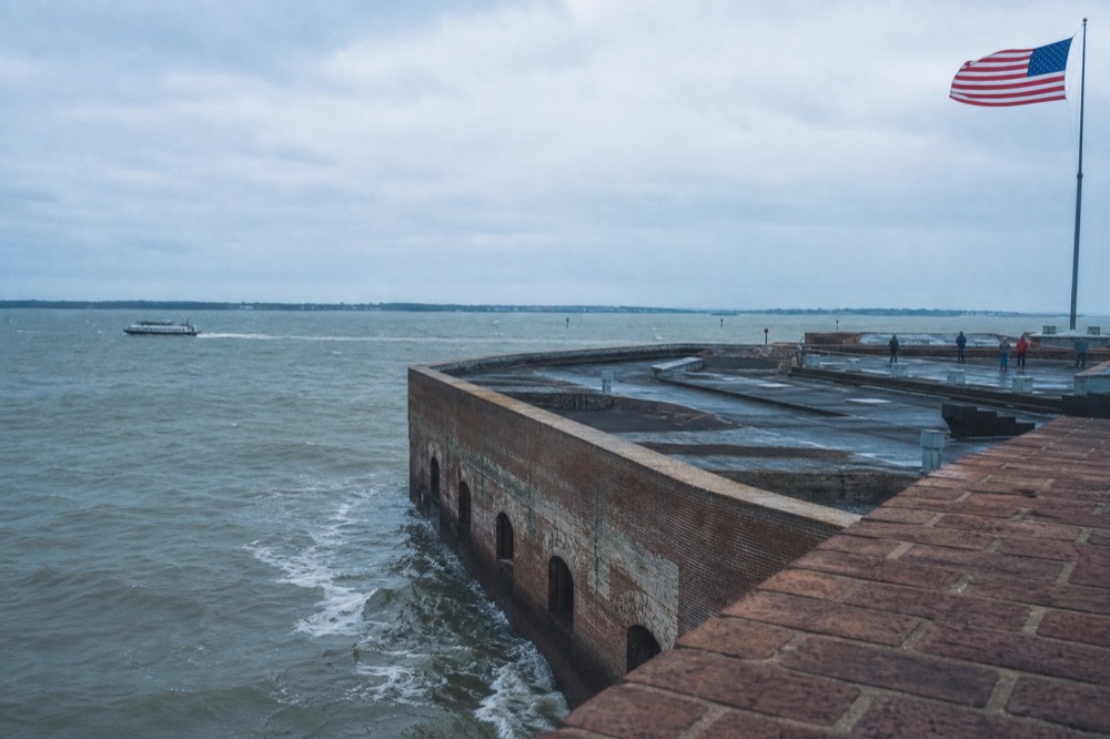 Fort Sumter's brick walls and flag flying over Charleston Harbor, no text, no logos, no people