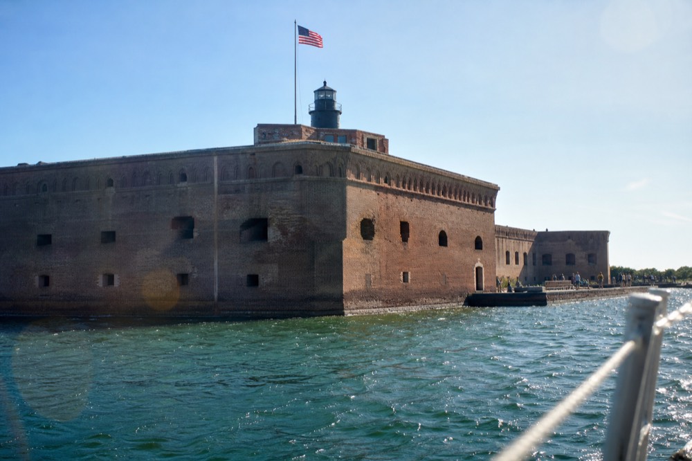 Fort Sumter's flag and brick fortifications seen from a passing boat, no text, no logos, no people