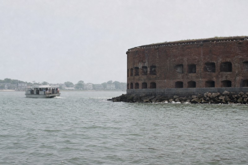 Historic brick harbor fort seen from a Charleston narrated history cruise boat under hazy midday light