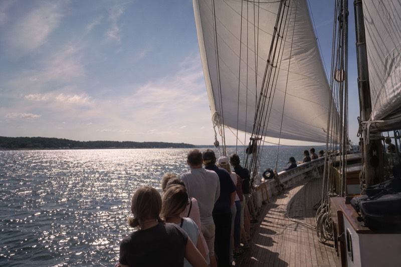 Schooner under full sail on a private Charleston harbor sailing charter with passengers along the rail