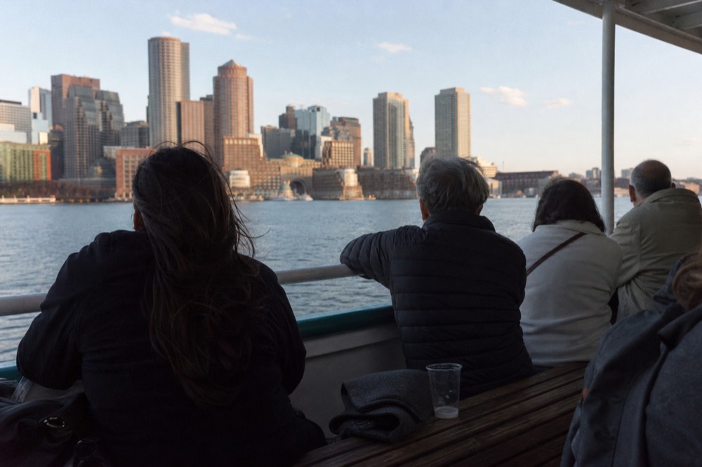 Passengers seated along the rail of a tour boat watching the downtown skyline, no text, no logos, no people.