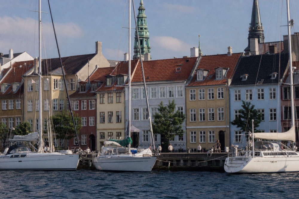 Historic pastel row houses and church steeples seen across the water, no text, no logos, no people