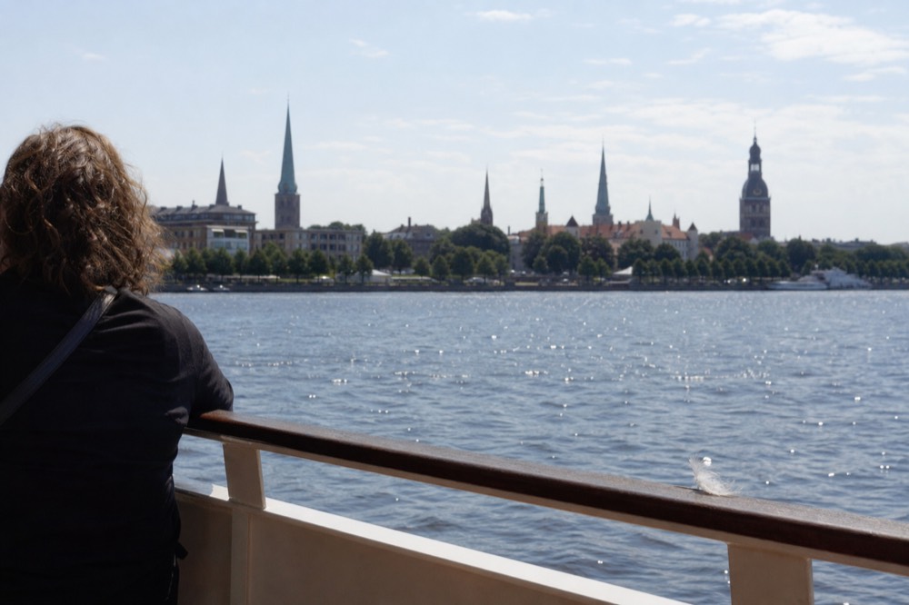 The Charleston skyline and church steeples seen across the harbor water from a boat deck, no text, no logos, no people