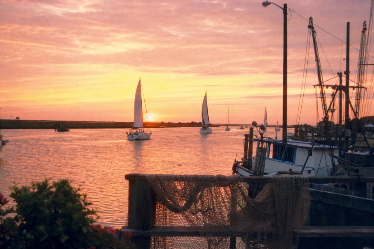 Charleston harbor at sunset with sailboats, no text, no logos, no people